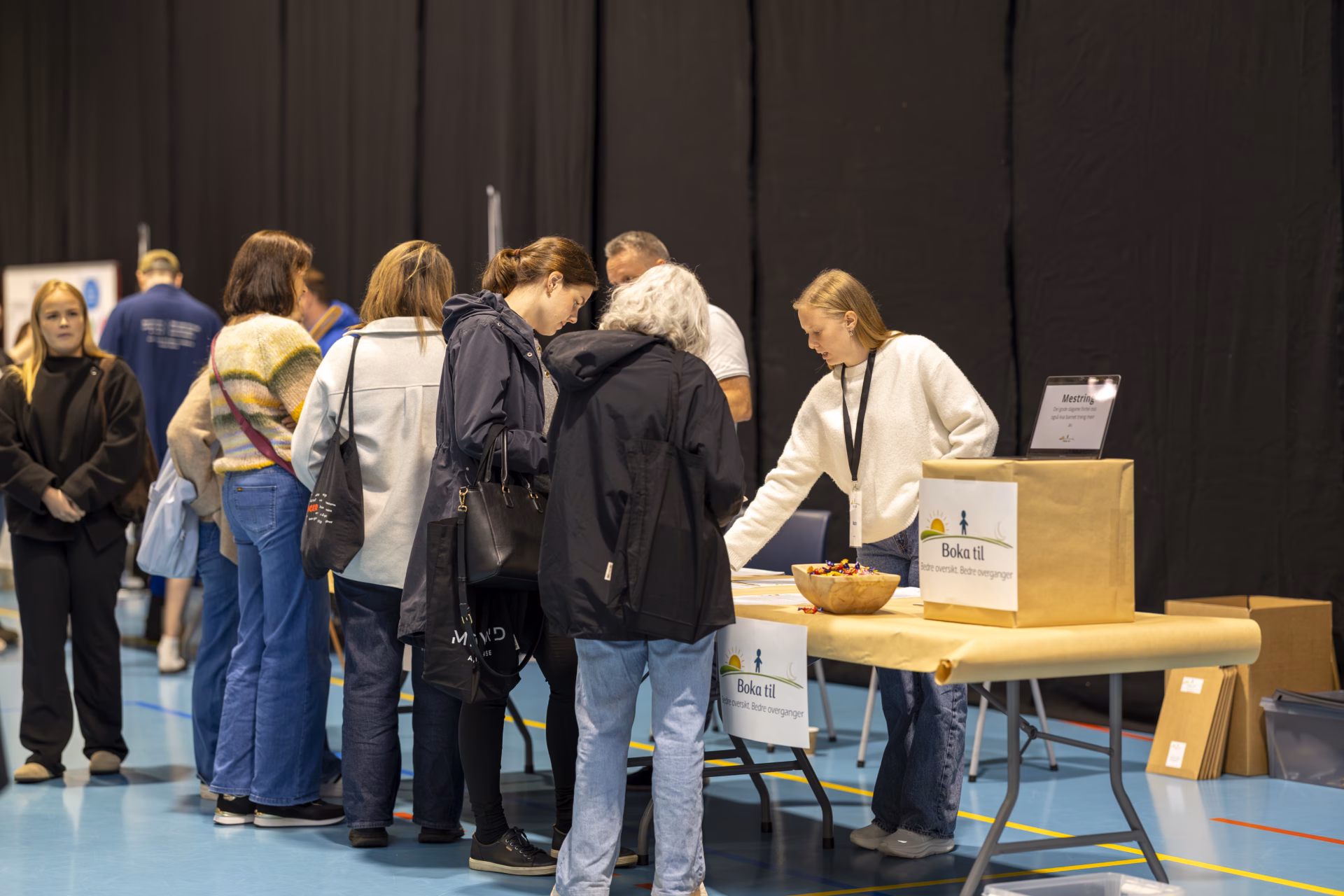 En gjeng med folk som står på ein utstillarstand